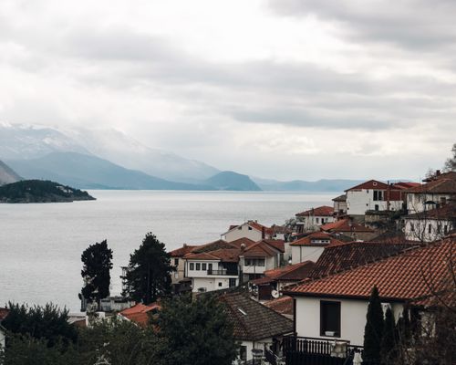 Free Picturesque landscape of Ohrid Lake with charming red-roofed homes in North Macedonia. Stock Photo