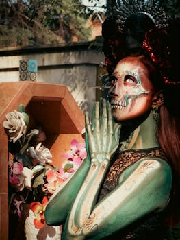 A woman with Catrina makeup and floral accessories celebrates the Day of the Dead outdoors.