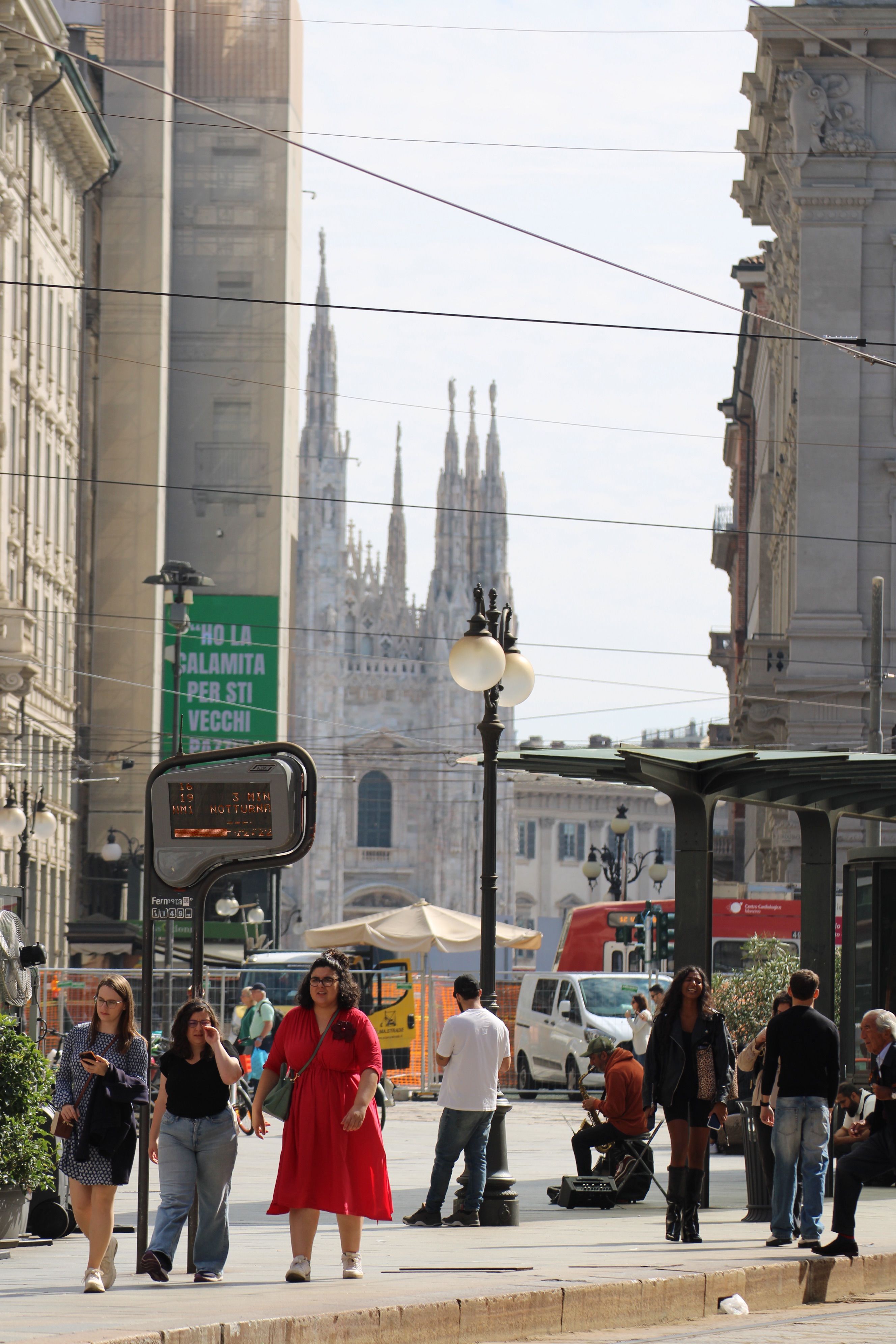 Bustling street scene with Milan Cathedral in the background, capturing daily city life.