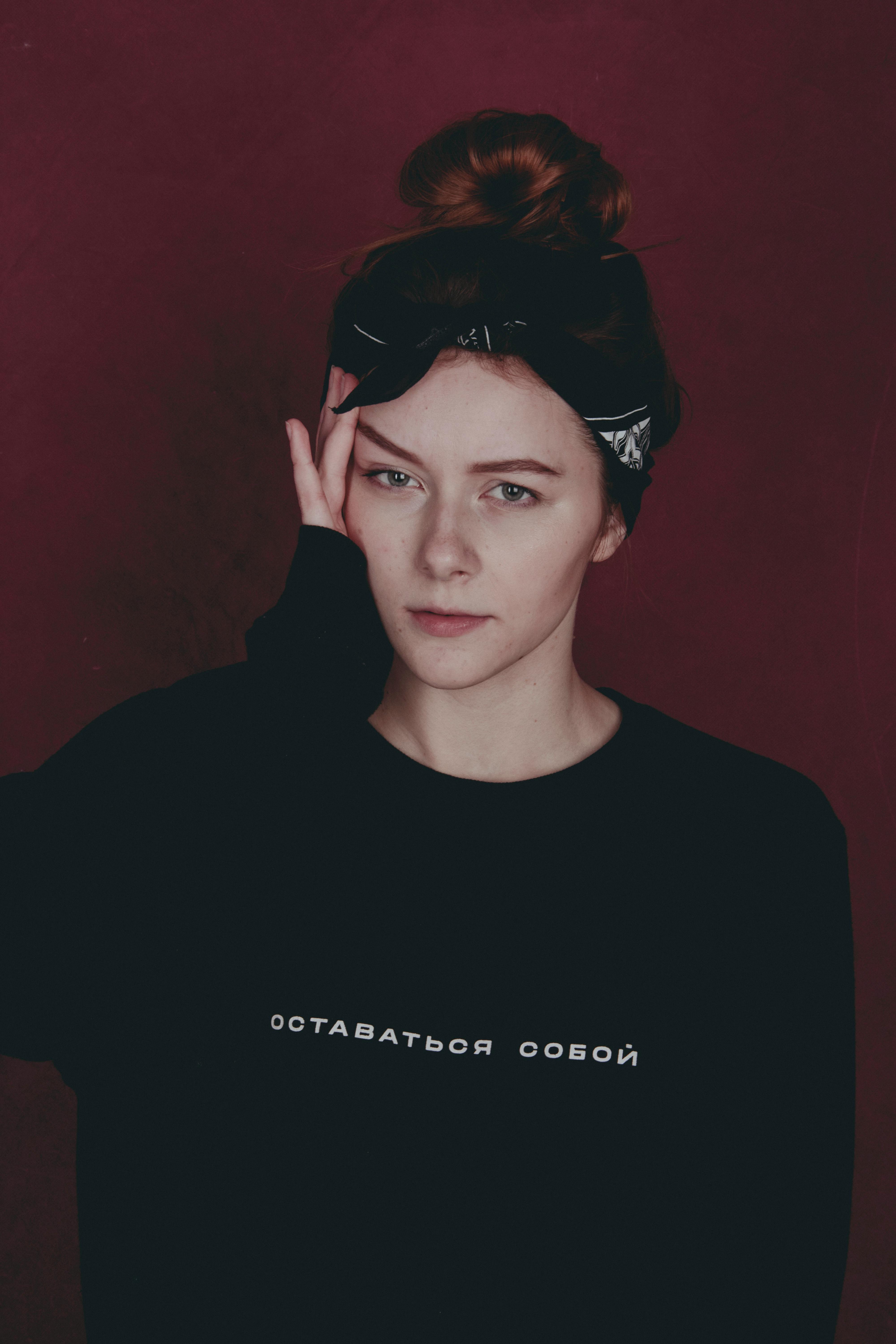 Stylish portrait of a young woman with a headband, showcasing individuality and fashion in a studio setting.