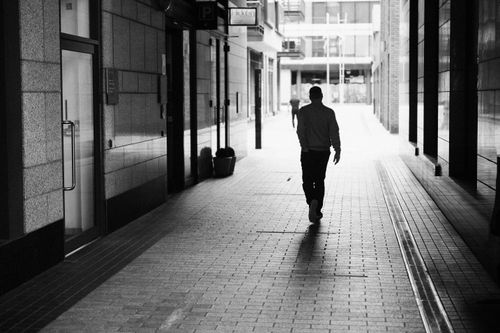 Free Monochrome photo of a man walking down a modern alleyway in Dublin, Ireland. Stock Photo