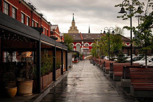 A quiet alley in Moscow with wet pavement and red brick buildings. Captures urban charm.