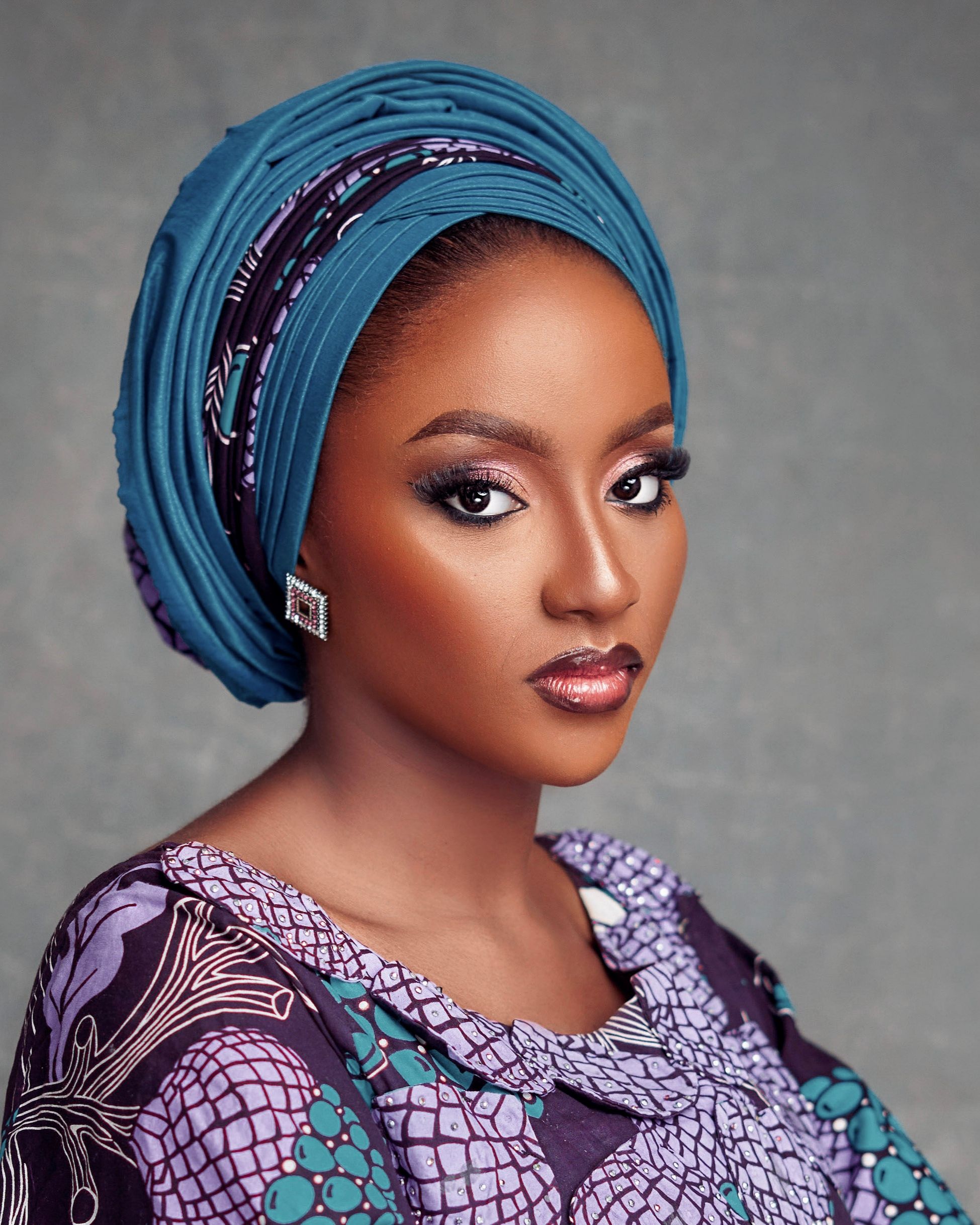 Captivating portrait of a woman wearing traditional Nigerian headwrap and attire, exuding elegance and grace.