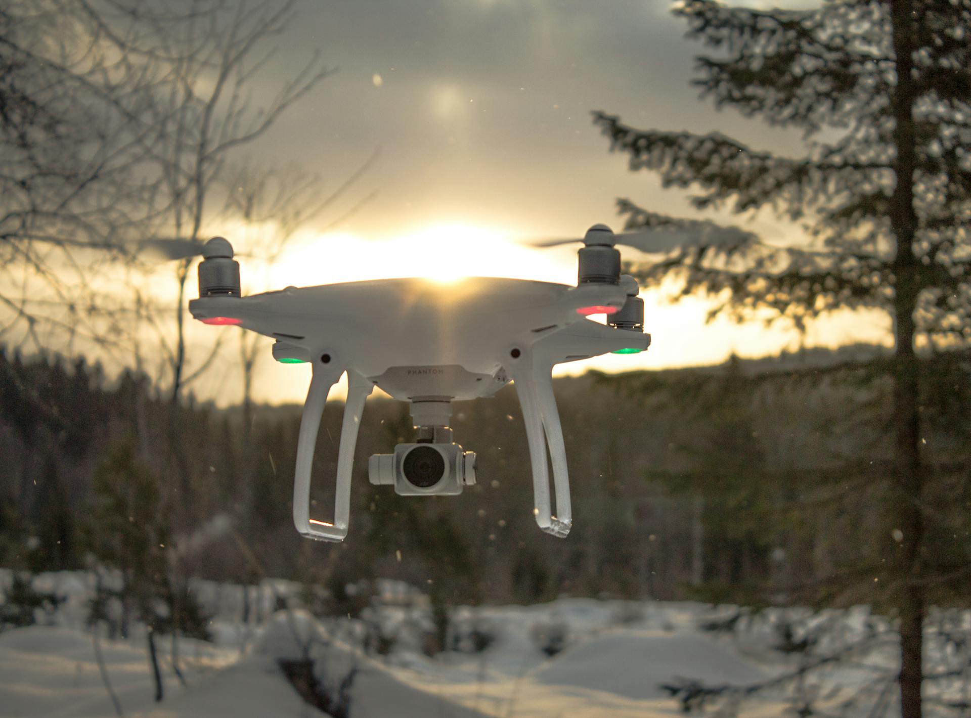 Photo of White Drone Quadcopter Flying Near Trees at Noontime