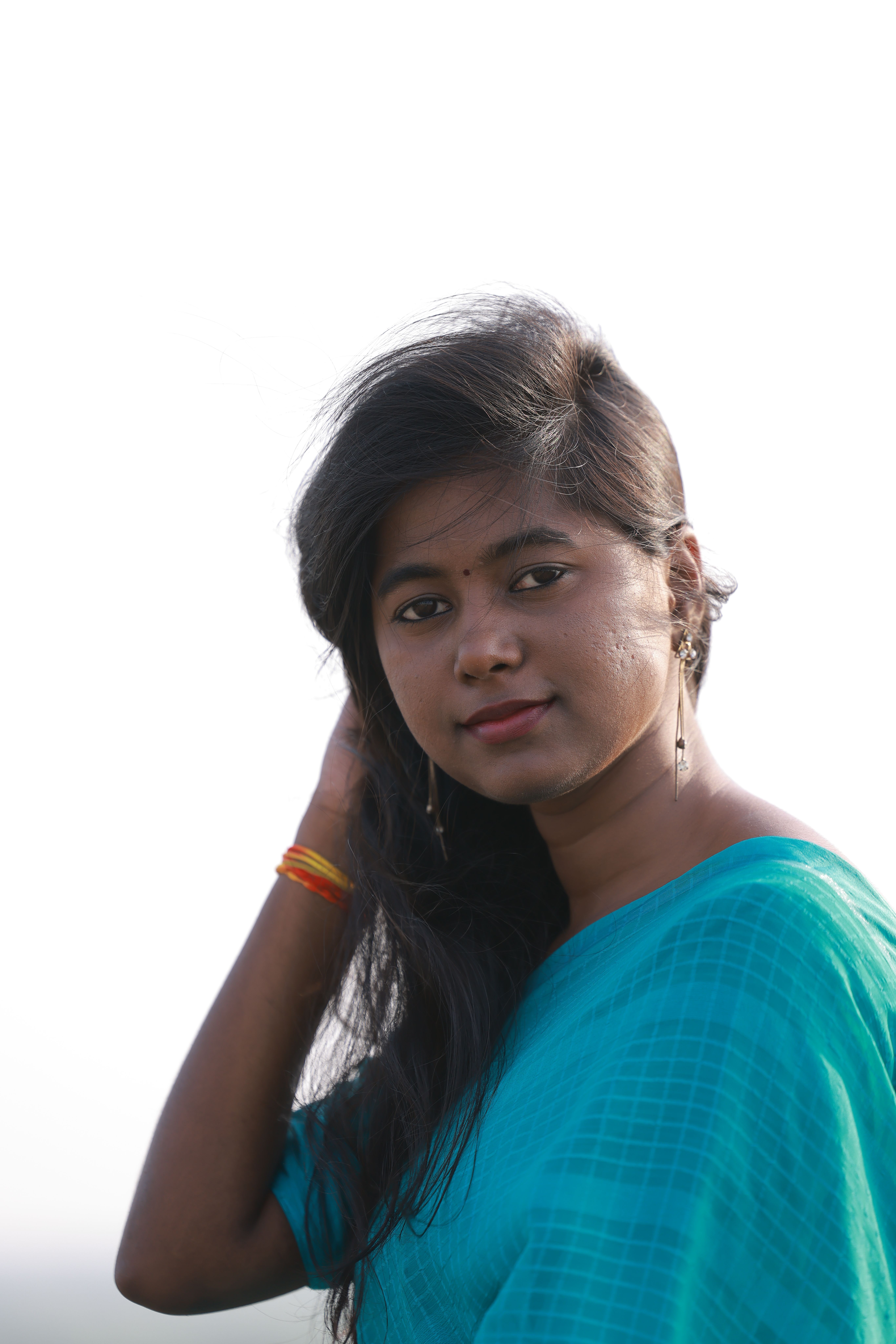 A serene portrait of a young woman outdoors, with tranquil expression and soft lighting.