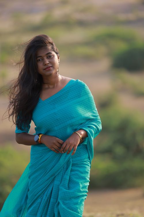 Free Young woman in a teal saree standing outdoors, exuding a serene and natural vibe. Stock Photo