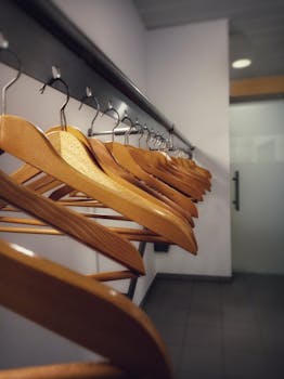 Neatly arranged wooden hangers in a modern indoor cloakroom setting, offering ample storage space.