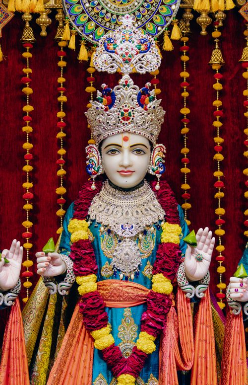 Free Ornate Hindu deity statue adorned with colorful garlands and elaborate jewelry. Stock Photo