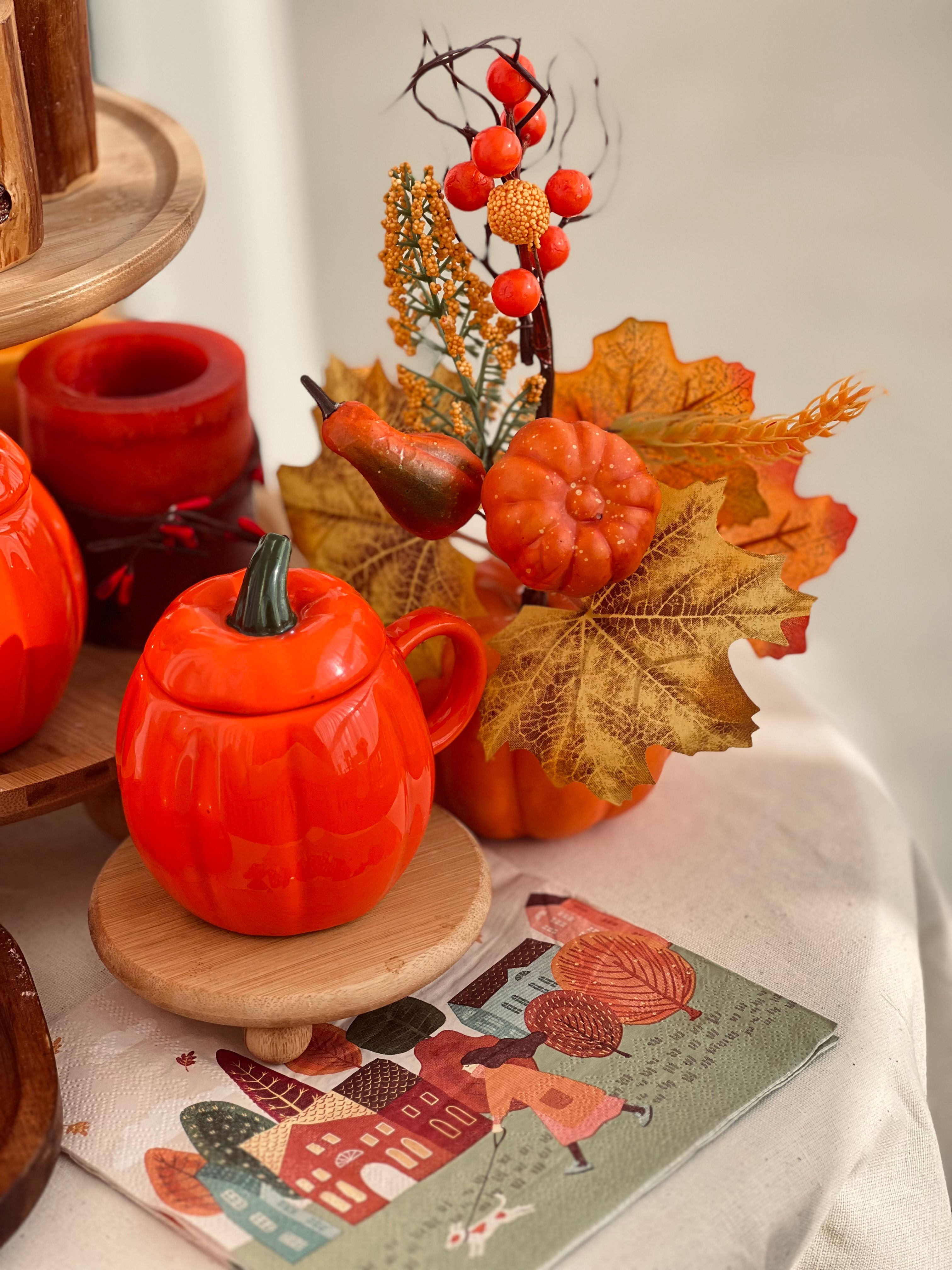 Table décorée avec citrouilles, feuilles et bougies pour l'automne