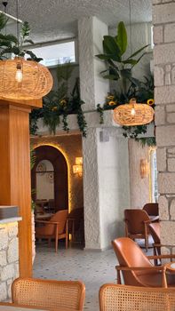 Elegant cafe interior featuring rustic decor, lush plants, and ample natural light.
