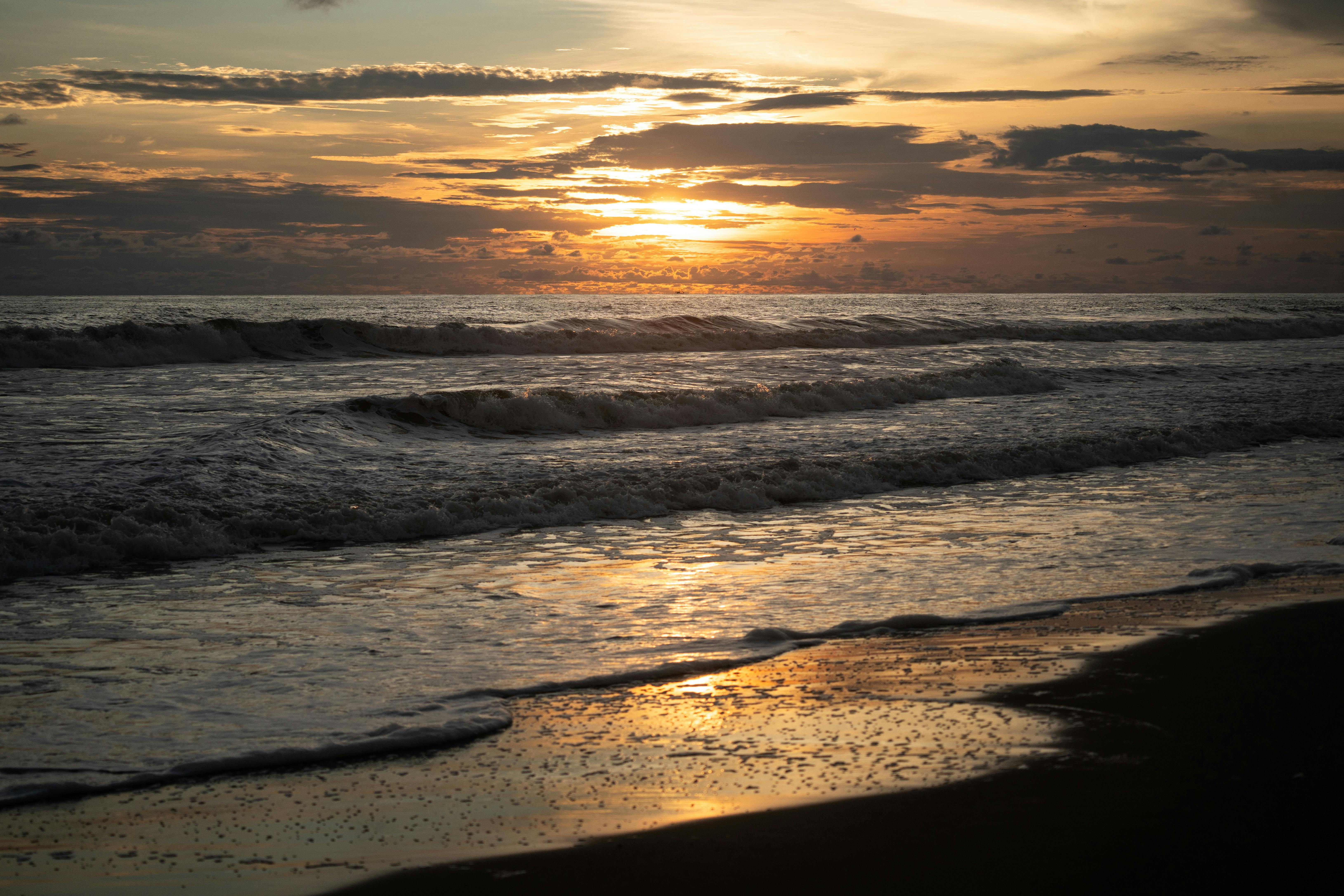 Beautiful sunset reflecting over the waves on Monterrico Beach, Guatemala, capturing a serene summer evening.
