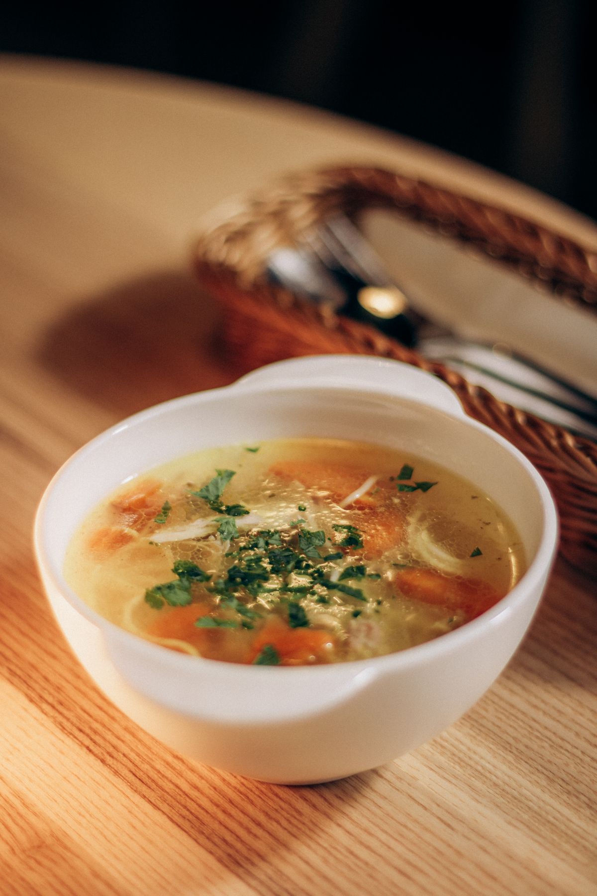 Warm chicken soup in a white bowl