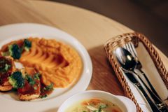 Warm vegetable soup and mashed sweet potatoes with broccoli, perfect for cozy dining.