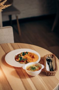 Cozy dinner scene with a gourmet meal on a wooden table, perfect for home dining themes.