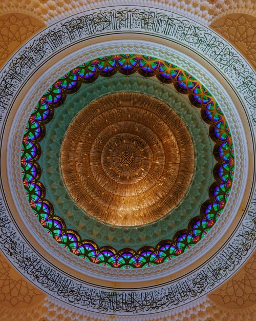 Free A beautifully detailed mosque dome featuring Arabic calligraphy and colorful patterns. Stock Photo