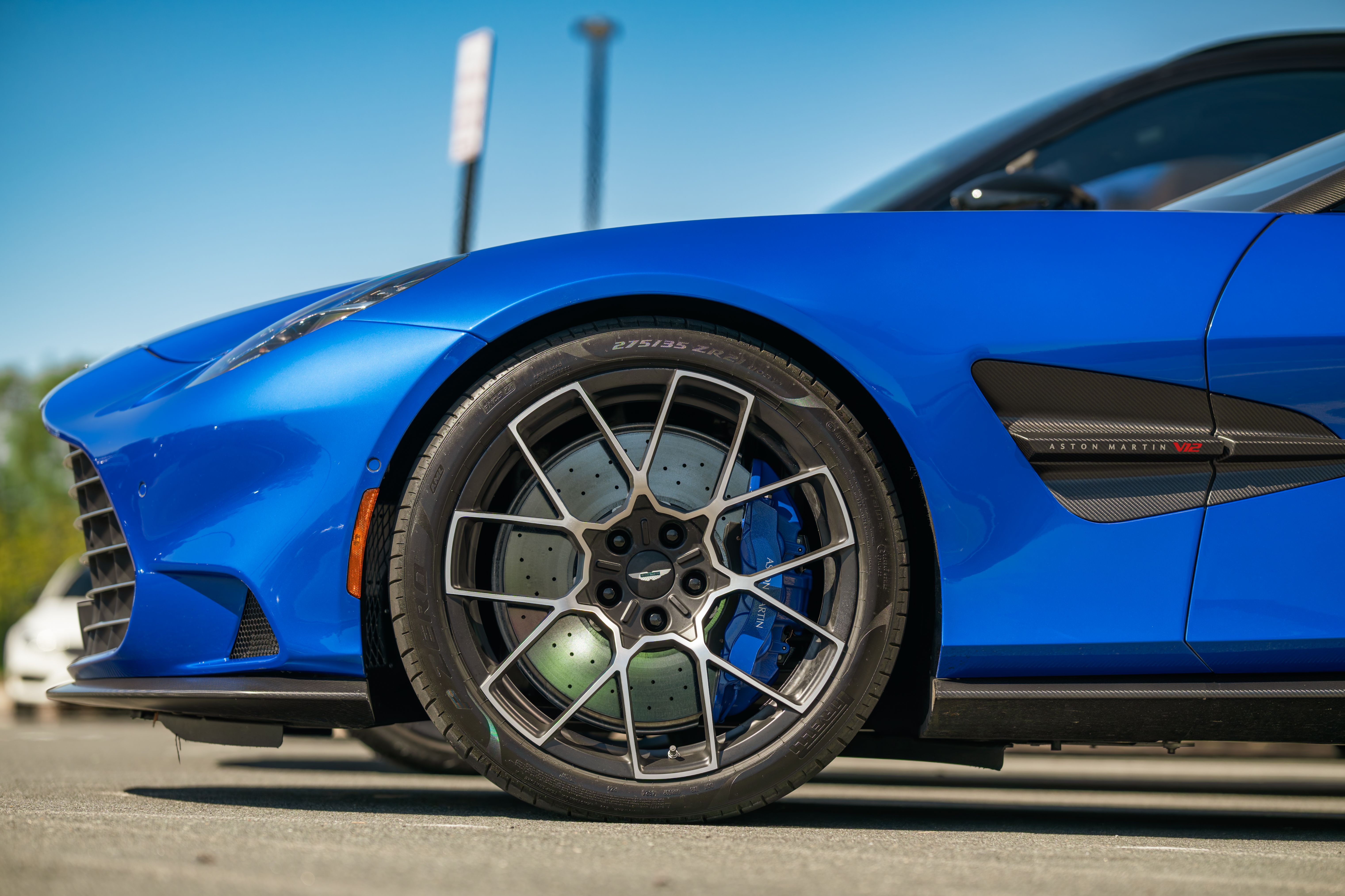 Close-up of a blue supercar with carbon fiber details and wheel