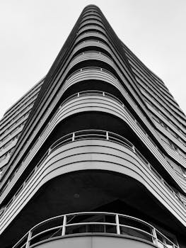 这张阿姆斯特丹现代摩天大楼的黑白照片，展现了其光滑的线条与曲线