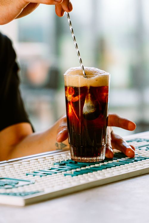 Free A refreshing glass of Fernet and Cola being stirred indoors in Buenos Aires. Stock Photo