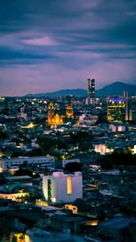 Stunning aerial view of a bustling city skyline at twilight, showcasing vibrant lights and architecture.