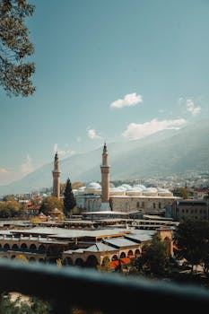 Panoramic view of Ulu Mosque in Bursa, Türkiye, with mountain backdrop.