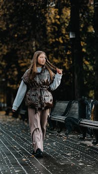 Fashionable woman strolling through a scenic autumn park, showcasing style and tranquility.