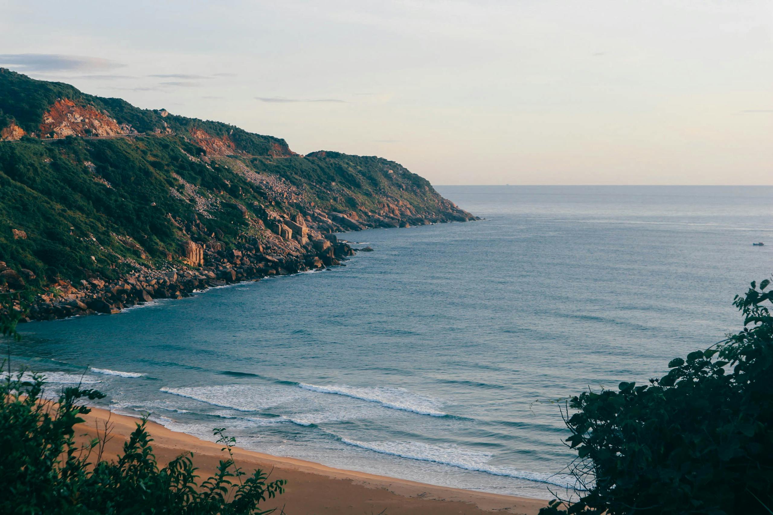 Breathtaking view of Mui Dien coastline with lush cliffs and tranquil ocean waters.