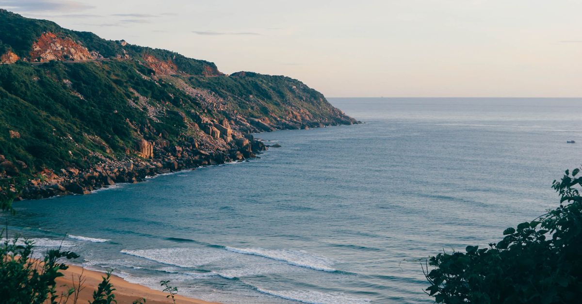Breathtaking view of Mui Dien coastline with lush cliffs and tranquil ocean waters.
