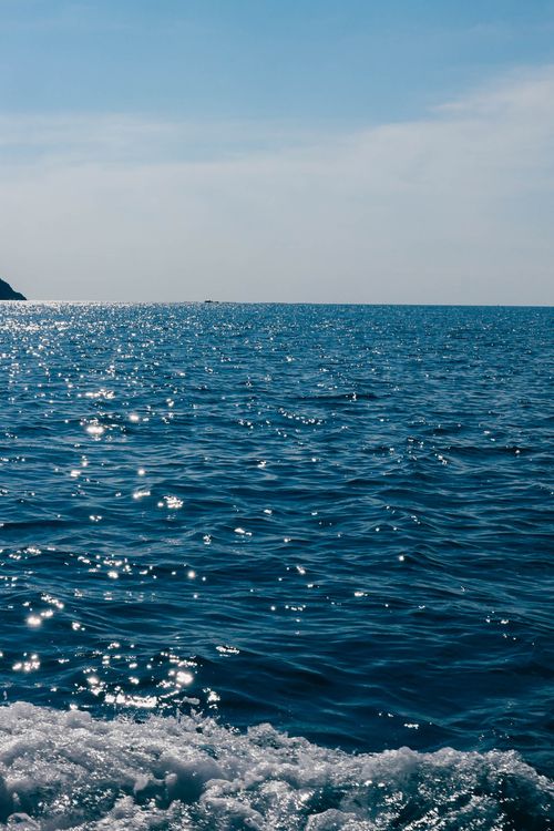 Free A serene ocean view with sparkling blue waves under a clear sky. Stock Photo