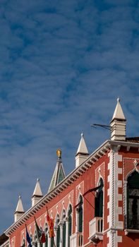 Elegant Venetian Gothic building against a deep blue sky, featuring pointed spires and ornate windows.