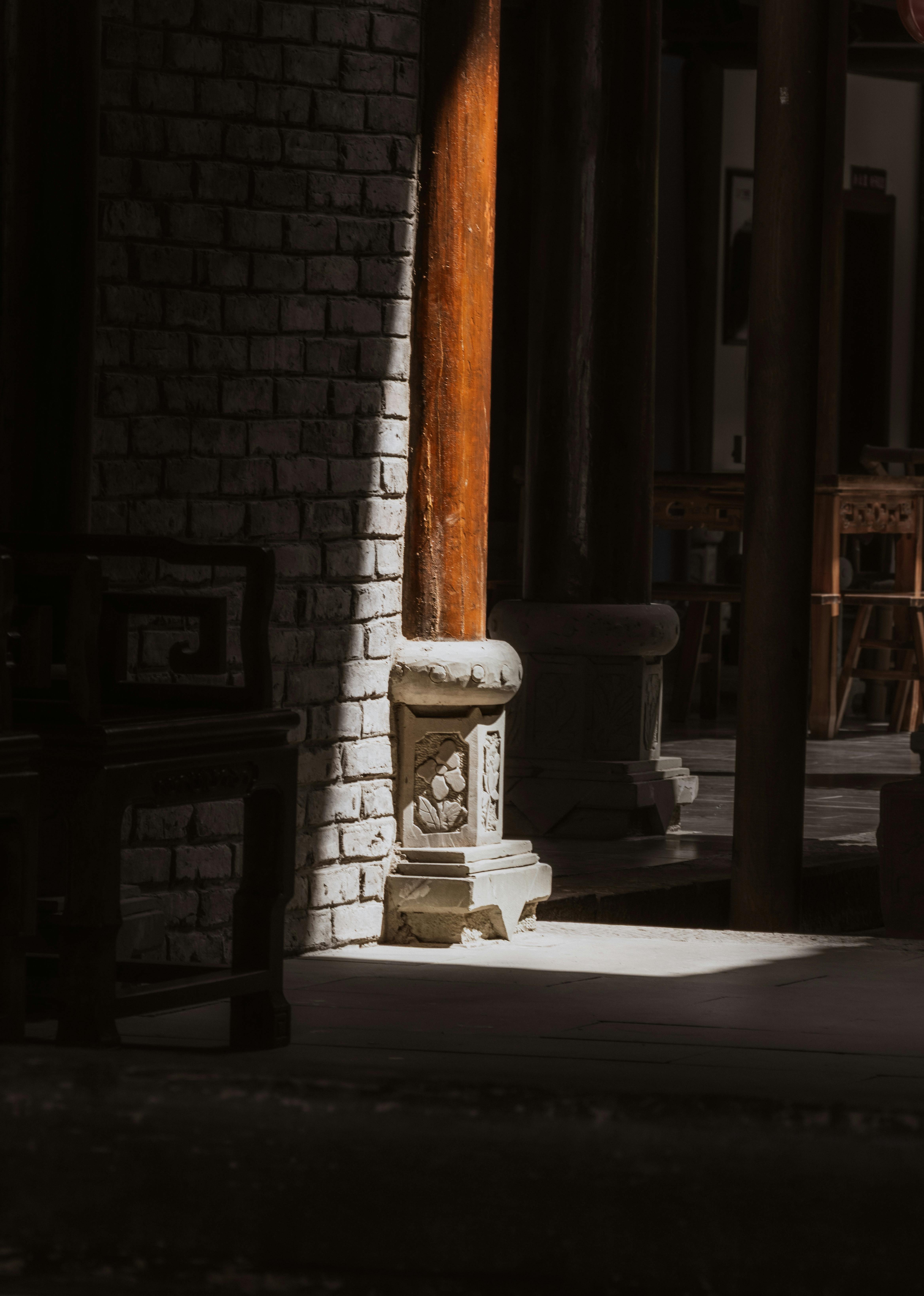 gratis Zonlicht werpt schaduwen op traditionele architectonische elementen in het interieur van een historisch gebouw. Stockfoto