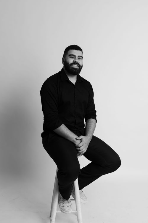 Free Black and white portrait of a man seated in a studio setting in São Paulo, Brazil. Stock Photo