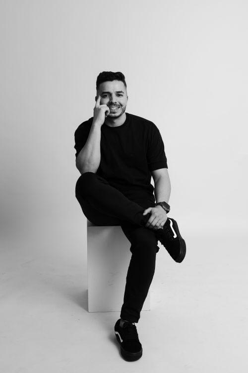 Free Black and white portrait of a smiling man sitting in a studio in São Paulo. Stock Photo
