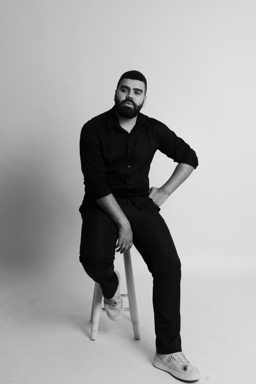 Free Elegant black and white portrait of a man seated in a studio setting. Stock Photo