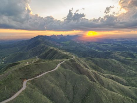 A breathtaking aerial view of a lush mountain range under a dramatic sunset in Belo Horizonte, Brazil.