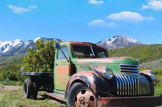 Rustic vintage truck set against the stunning backdrop of Colorado's snowy mountain peaks.