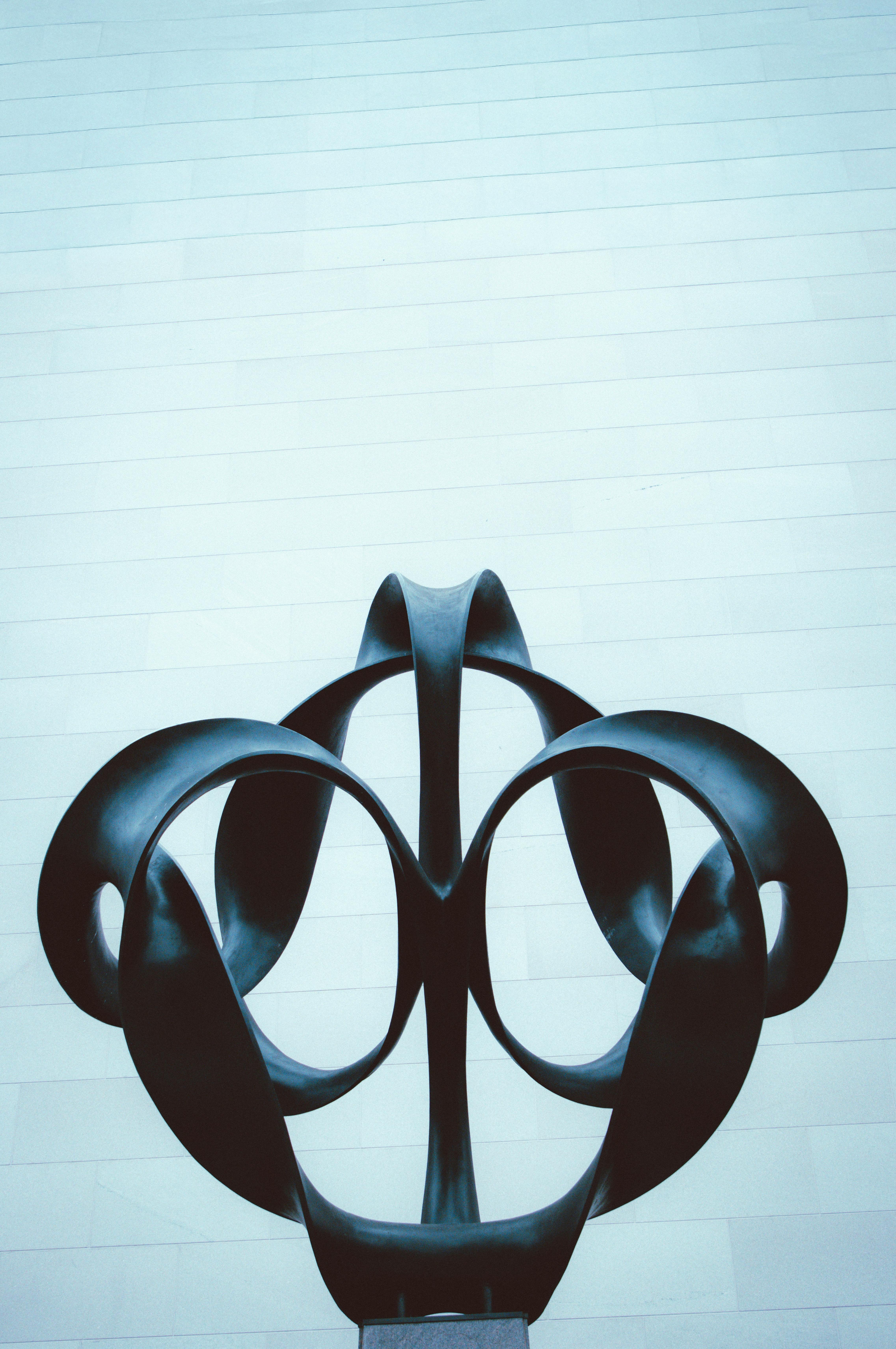 Free Artistic black sculpture with minimalist backdrop, ideal for modern design themes. Stock Photo