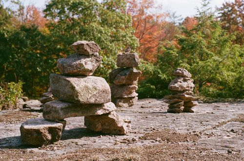 Free Beautiful autumn scene with balanced stone cairns in a forest, vibrant foliage. Stock Photo