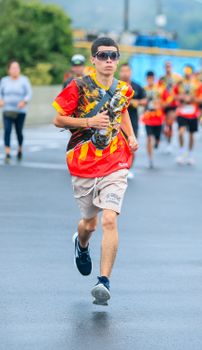 Focused runner in colorful attire participating in outdoor marathon event.