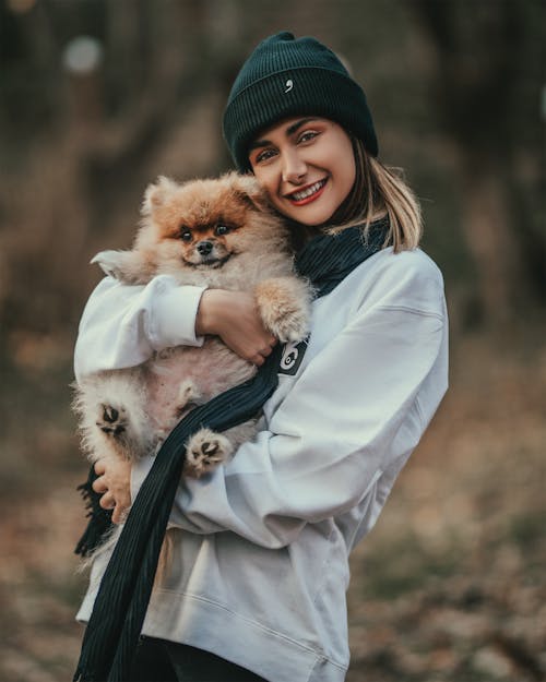 犬を運ぶ女性の浅いフォーカス写真