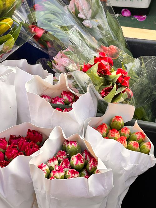 Free Colorful bouquets of flowers wrapped in white paper at a market stall. Stock Photo