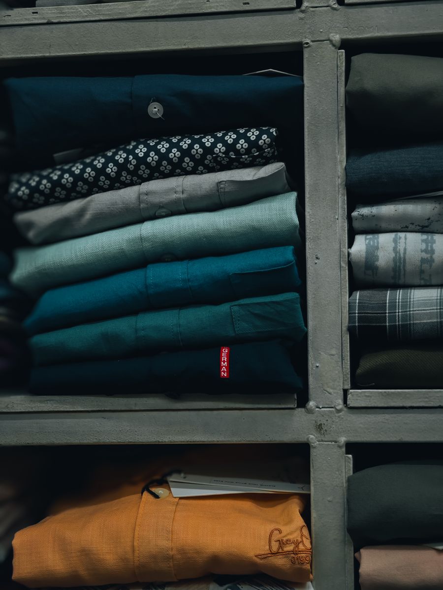 Neatly folded tees in many colours on a shelf