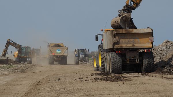 Heavy machinery moving earth and debris at land clearing site