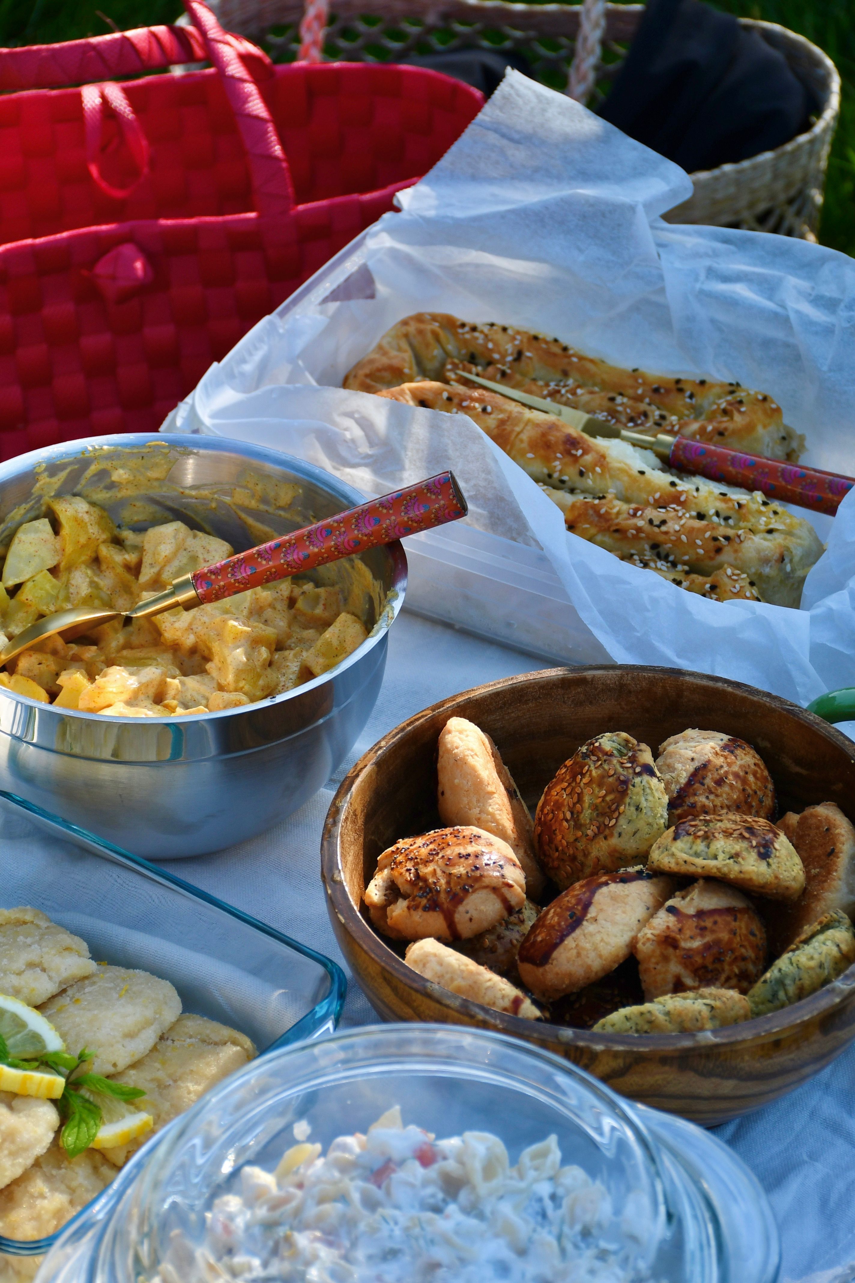 A vibrant picnic setup with savory snacks and dip outdoors.