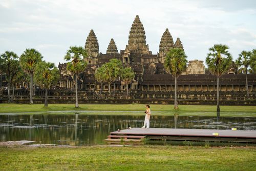Free A person enjoys a serene walk near the iconic Angkor Wat temple in Siem Reap, Cambodia. Stock Photo