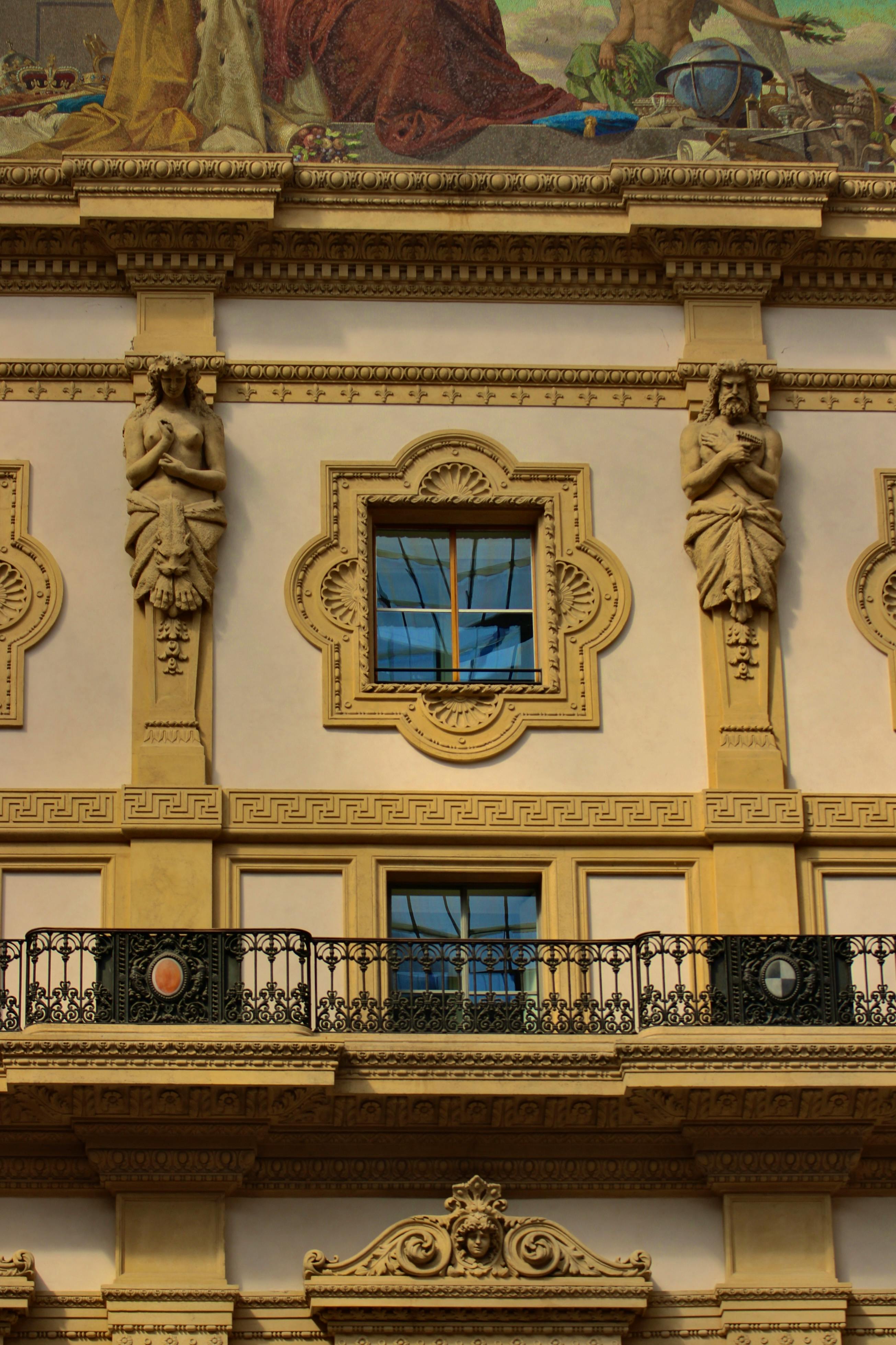 Free Detailed view of a building facade with ornate sculptures and window in Milan, Italy. Stock Photo