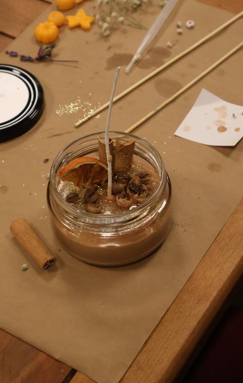 Free Handcrafted candle with dried orange and spices on a rustic setup. Stock Photo