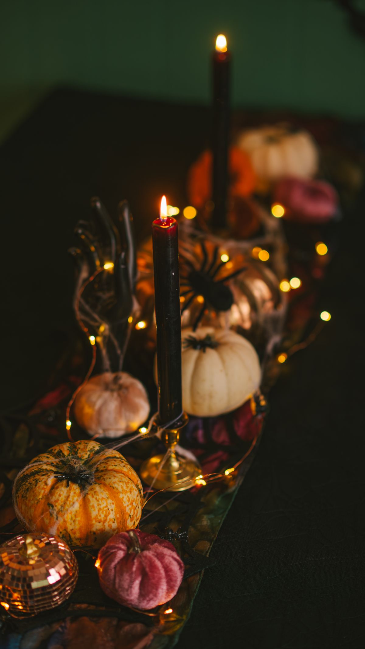 Sophisticated fall table setting with pumpkins, candles, and warm lighting