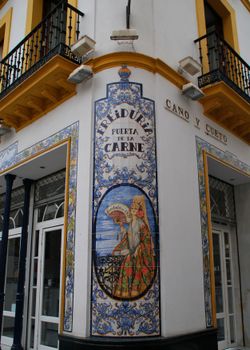 Decorative Spanish tilework azulejo on a building in Sevilla's historical area.