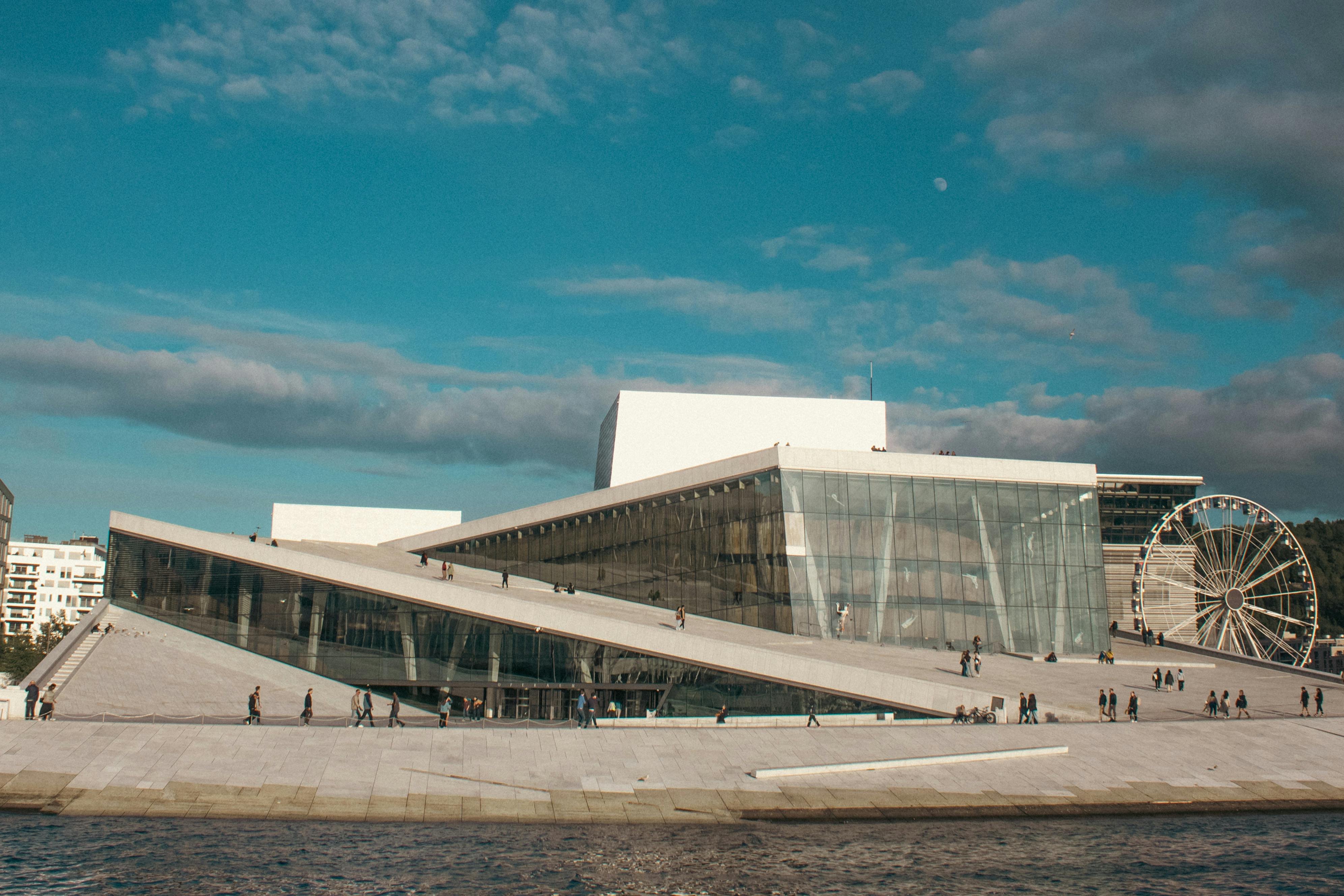 Explore the stunning modern architecture of Oslo Opera House with vibrant summer skies.
