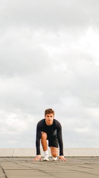 Focused athlete in a starting position on an outdoor track preparing for a sprint in España, showcasing determination.
